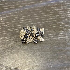 Silver tone filigree brooch with black rhinestones